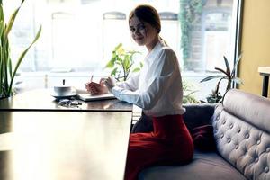 Seite Aussicht von ein Frau im ein Weiß Hemd und ein rot Rock im ein Restaurant foto
