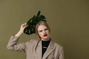 Porträt von ein Frau rot Lippen Palme Blatt Charme Mode isoliert Hintergrund foto