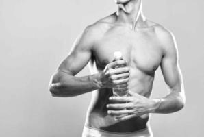 sportlich Mann Wasser Flasche muskulös Körper Studio posieren foto