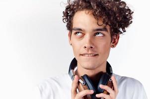 heiter Kerl mit lockig Haar Kopfhörer Technologie Musik- Emotionen foto