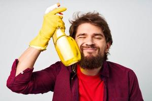 Mann mit Waschmittel im Gummi Handschuhe Hände Bedienung Fachmann foto