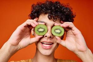 Kerl mit Kiwi lockig Haar in der Nähe von Augen abgeschnitten Aussicht rot Hintergrund foto