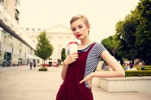 heiter Frau draußen Gehen im Glas mit Mode trinken foto