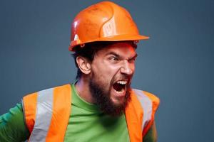 emotional Bauherren Orange schwer Hut Sicherheit Arbeit ermüden Blau Hintergrund foto