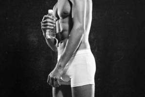 sportlich Männer im Weiß kurze Hose gepumpt oben Drücken Sie posieren Fitness dunkel Hintergrund foto