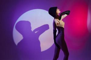 schön modisch Mädchen posieren auf Bühne Scheinwerfer Silhouette Disko lila Hintergrund unverändert foto