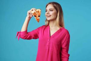 Frau im ein Rosa Hemd mit Pizza im ihr Hände Müll Essen Nahansicht foto