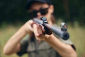 Frau auf draussen Schnauze von das Gewehr Sicht Jagd Waffen foto