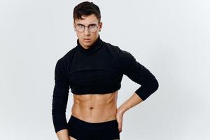 sportlich Mann mit ein aufgepumpt Torso im ein Sweatshirt hält seine Hand auf seine Gürtel auf ein Licht Hintergrund Bodybuilder Fitness foto