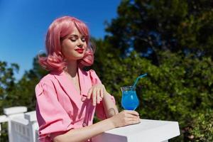 glamourös Frau genießen ein bunt Cocktail Hotel Terrasse Trinken Alkohol foto