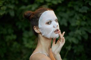 Porträt von ein Frau Weiß Maske behalten Ihre Hand in der Nähe von Ihre Gesicht Kosmetologie foto