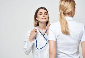 Krankenschwester im medizinisch Kleid Stethoskop und geduldig zurück Aussicht foto