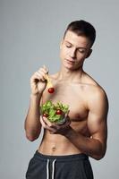 Kerl halten ein Teller von Salat Essen Diät Energie Gesundheit Essen Aufnahme foto
