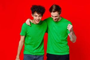 komisch freunde Grün T-Shirts Umarmungen Emotionen Freude rot Hintergrund foto