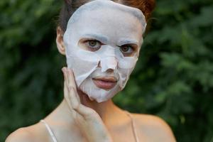 Porträt von ein Mädchen kosmetisch Maske berühren Ihre Gesicht mit Ihre Hand klar Haut foto