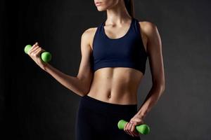 Sport Zahl von ein Frau mit Hanteln im Hände Übungen Motivation dunkel Hintergrund foto