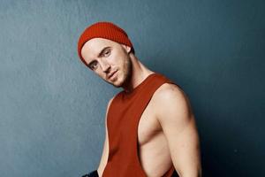 gut aussehend Mann tragen Hut rot t Hemd Mode posieren Studio foto