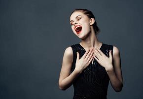 energisch Frau im schwarz Kleid Gesten mit Hände Emotionen Modell- Überraschung Freude foto