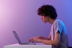 Mann Cyberspace spielen mit im Vorderseite von ein Laptop violett Hintergrund foto