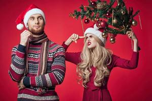 heiter jung Paar Weihnachten Baum Spielzeuge Urlaub rot Hintergrund foto