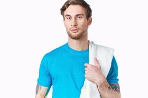 Mann im Blau T-Shirt Handtuch auf Schulter abgeschnitten Aussicht Farbe Hintergrund Fitness foto