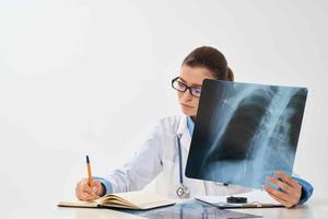 Arzt sitzt beim das Tabelle Röntgen Bild Radiologe Forschung foto