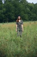 Frau auf Natur Stehen im ein Feld hoch Gras foto