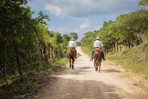 2016 - zwei Cowboys reiten auf der Straße foto