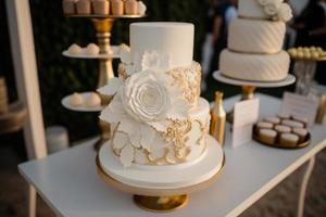 Hochzeit Kuchen mit Blume Einzelheiten auf ein Tischwas tut Hochzeit Kuchen bedeuten foto