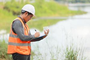 Umwelt Ingenieure Arbeit beim Wasser Quelle zu prüfen zum Verunreinigungen im Wasser Quellen und Analysieren Wasser Prüfung Ergebnisse zum wiederverwenden.welt Umgebung Tag Konzept. foto