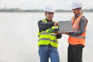 Umwelt Ingenieure Arbeit beim Wasser Quelle zu prüfen zum Verunreinigungen im Wasser Quellen und Analysieren Wasser Prüfung Ergebnisse zum wiederverwenden.welt Umgebung Tag Konzept. foto