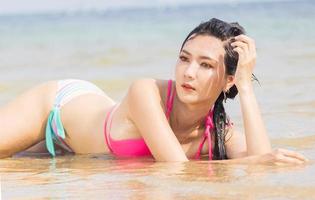 schöne asiatische Frau, die glücklich am Strand faulenzt foto