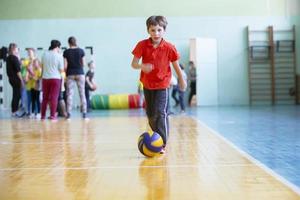 öffnen Lektion im physisch Bildung.Kind im das Turnhalle.Kind mit ein Ball im ein physisch Bildung Lektion. foto