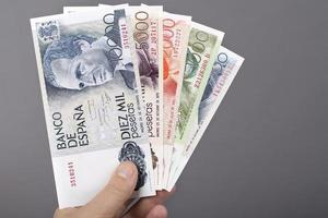 Spanisch Geld im das Hand auf ein grau Hintergrund foto