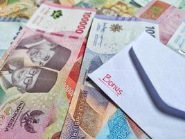 ein Porträt von ein Weiß Briefumschlag Das sagt Bonus mit Neu indonesisch Banknoten wie das Hintergrund foto