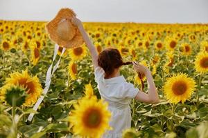 Frau Porträt im ein Hut auf ein Feld von Sonnenblumen Landschaft foto