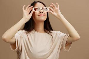 ziemlich Frau im ein Beige T-Shirt mit Brille posieren Kleidung Mode Studio Modell- foto
