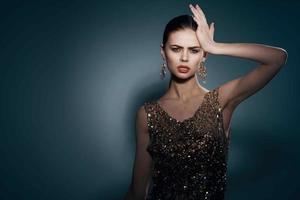 heiter ziemlich Frau auf ein golden Kleid hell bilden Studio Luxus foto