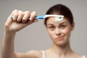 Frau im Weiß T-Shirt Dental Hygiene Gesundheit Pflege Licht Hintergrund foto