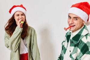 heiter Mann und Frau festlich Rohre Weihnachten Neu Jahr Hüte Spaß foto