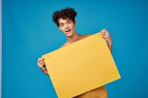 komisch lockig Jungs mit ein Gelb Scharf Werbung Kopieren Raum Blau Hintergrund foto