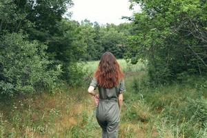 Brünette Frau im Overall auf das Wiese zurück Aussicht foto