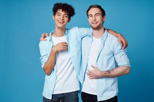 freunde umarmen auf ein Blau Hintergrund Spaß passend Hemden Weiß T-Shirt Hose foto
