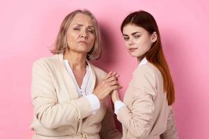 Mama und Tochter Umarmung zusammen Familie Pflege Rosa Hintergrund foto