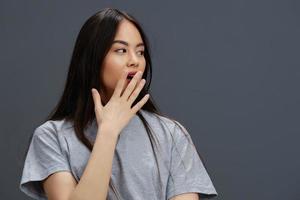 schön Frau im ein T-Shirt und Jeans posieren Jugend Stil grau Hintergrund foto