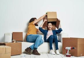 Mann und Frau sitzen auf Weiß Couch Kisten mit ziehen um Lebensstil Dinge foto