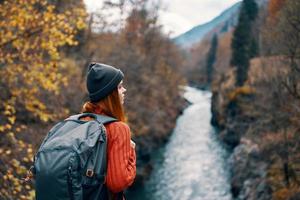 Frau Wanderer mit Rucksack auf ihr zurück in der Nähe von Berg Fluss im Natur foto