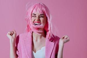 positiv jung Frau im ein Rosa Blazer Rosa Perücke abgeschnitten Aussicht Rosa Hintergrund unverändert foto