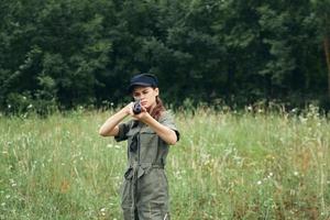 Frau Soldat Frau mit Waffe im Hand Jagd Natur Lebensstil schwarz Deckel foto