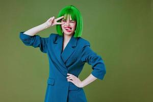 Porträt von ein charmant Dame Spaß Geste Hände Grün Haar Mode Grün Hintergrund unverändert foto
